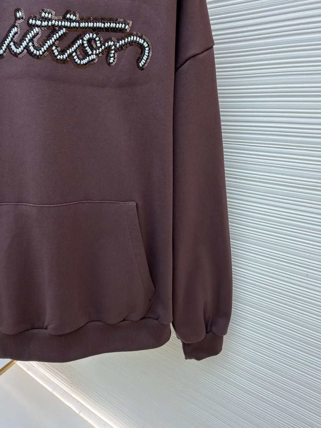 LOUIS VUITTON beaded embroidered letter hooded sweatshirt ●Item number: 1682118-A60 ●Material: pure cotton fish scale base fabric ●Technology: Pearl embroidery production ●Color: brown ●Version: fitted version ●Weight: about 830 grams ●Size: S-M-L-XL ●Description: The fabric is made of 26S double yarn + 10S fish scale bottom brushed fabric, weight 380g, with 21S double yarn 2*2 rib, weight 380g. This kind of fabric is treated with fleece to form a layer of soft and plump fluff on the inside; the improved fish scale knitting method forms a delicate concave and convex texture on the bottom surface, similar to the arrangement of fish scales. Effectively increases the air storage layer and improves thermal insulation performance. The front of the fabric is smooth and smooth, while the back is soft and waxy. It has excellent moisture absorption, breathability, wrinkle resistance and drape, and is thicker and crisper than ordinary sweatshirt materials. It gives clothes excellent warmth retention, breathability and skin-friendly touch. The Vuitton script on the chest is embroidered with beads. During the embroidery process, tiny beads are fixed on the fabric together with embroidery thread. The direct characteristics brought by this process are a strong three-dimensional sense, a unique sense of weight and a reflective effect that changes with the light. The overall wiring is straight and delicate, the fabric is comfortable and soft, and the color is consistent without color difference. It can be matched with the same style to create a fashionable look and control various occasions. Customized accessories, complete with three standards, same style for men and women!